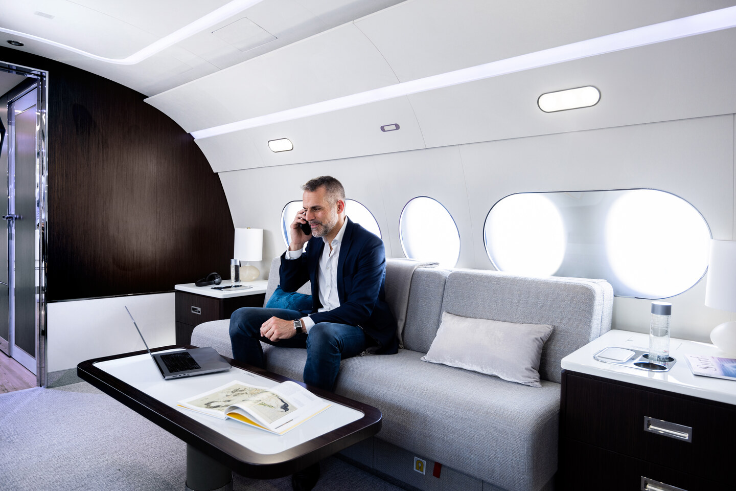 Glavni salon poslovnega letala Airbus ACJ TwoTwenty z naslanjači, mizo in velikim zaslonom